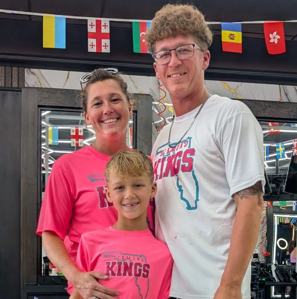 After donating hair to Wigs For Kids, Pryor poses with family members in a barbershop, celebrating a meaningful milestone and a new haircut.