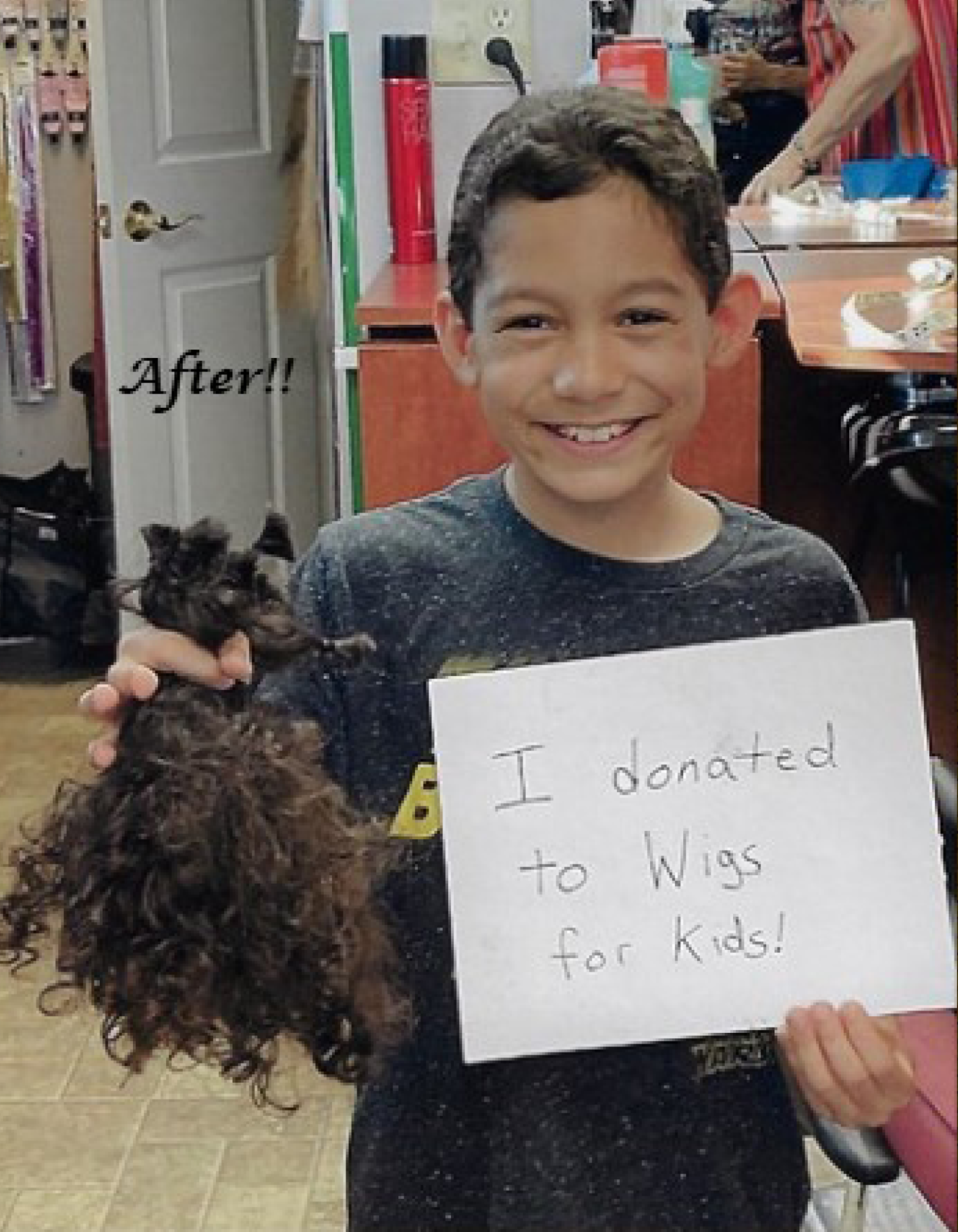 A boy holding his cut ponytails along with a paper sign saying "I donated to Wigs For Kids!"
